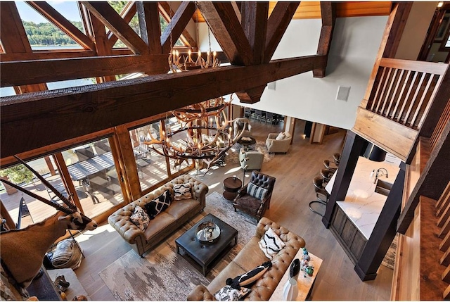 living room featuring high vaulted ceiling, a chandelier, beamed ceiling, and hardwood / wood-style flooring