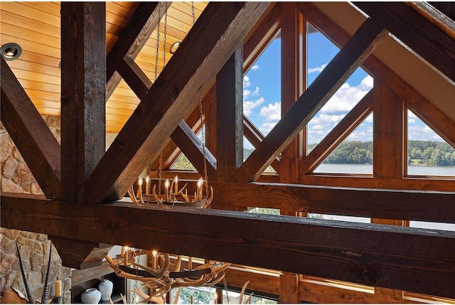 interior details with a notable chandelier, wood ceiling, a water view, and beamed ceiling