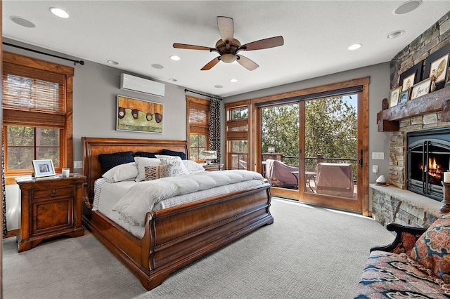 carpeted bedroom with ceiling fan, access to outside, a fireplace, and multiple windows