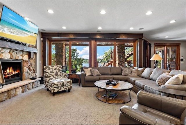 carpeted living room with a textured ceiling and a fireplace