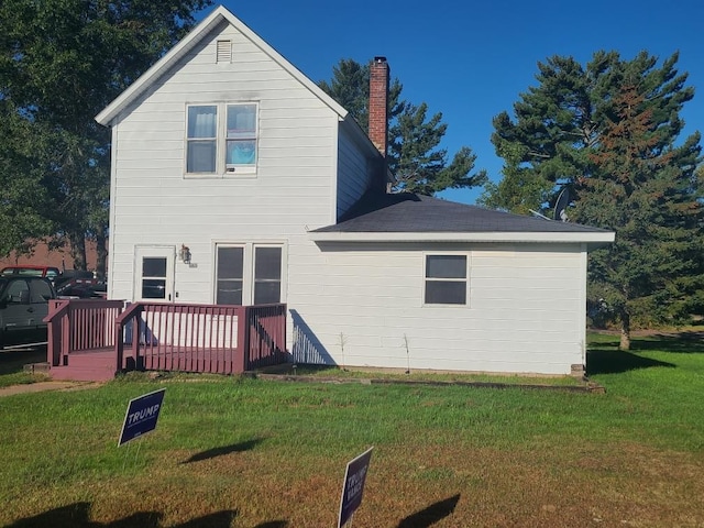 rear view of house featuring a deck and a yard