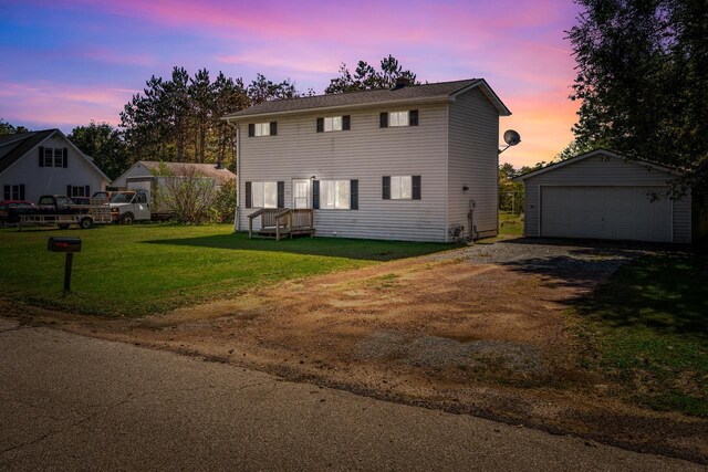 view of front facade featuring a lawn, an outbuilding, and a garage