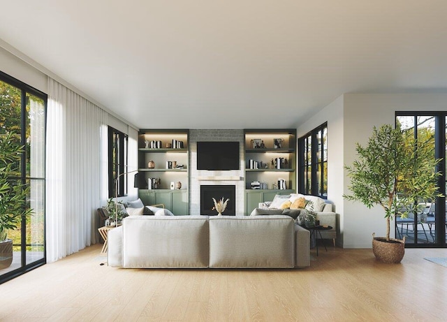 living room with a fireplace, built in shelves, light wood-type flooring, and a healthy amount of sunlight