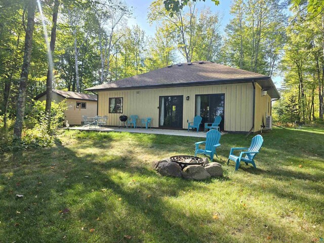 back of house featuring a patio, a yard, and an outdoor fire pit