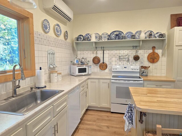 kitchen featuring white cabinets, white appliances, plenty of natural light, and sink