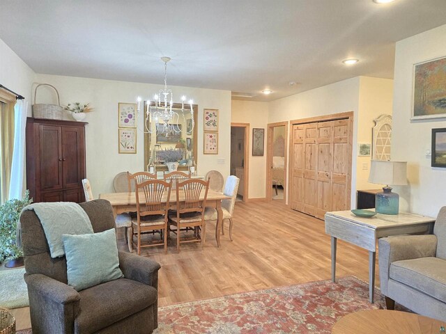 dining space with an inviting chandelier and light wood-type flooring