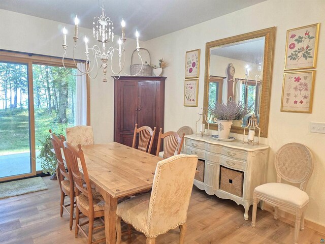 dining area featuring wood-type flooring and a notable chandelier