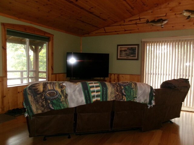 living room with wood-type flooring, wood ceiling, wood walls, and lofted ceiling