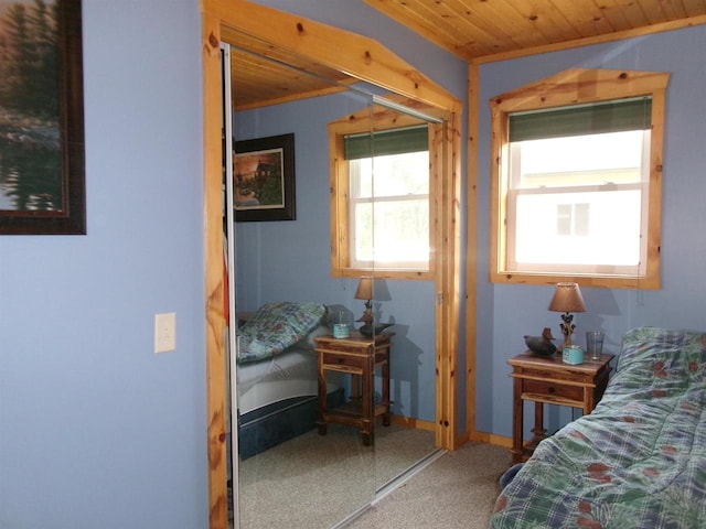 carpeted bedroom with a closet and wooden ceiling