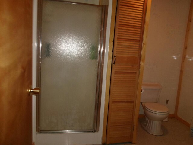 bathroom featuring toilet and an enclosed shower