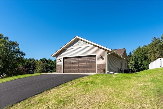 view of front of home with a front lawn, central AC unit, and a garage