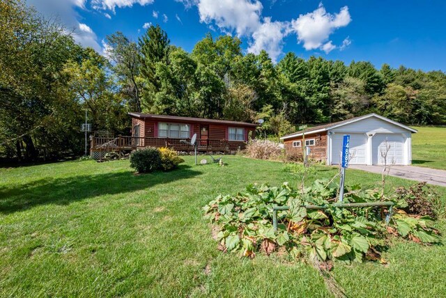 view of front facade with a front yard, an outdoor structure, a garage, and a deck