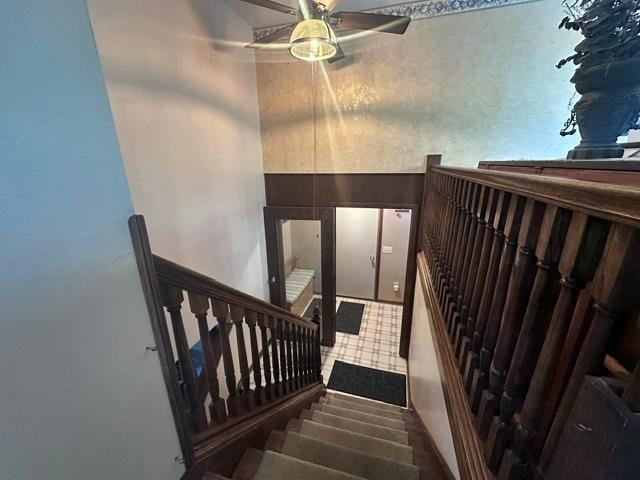 staircase featuring ceiling fan