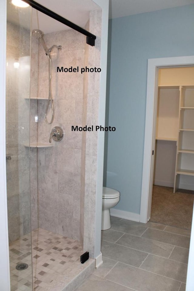 bathroom with walk in shower, toilet, and tile patterned flooring