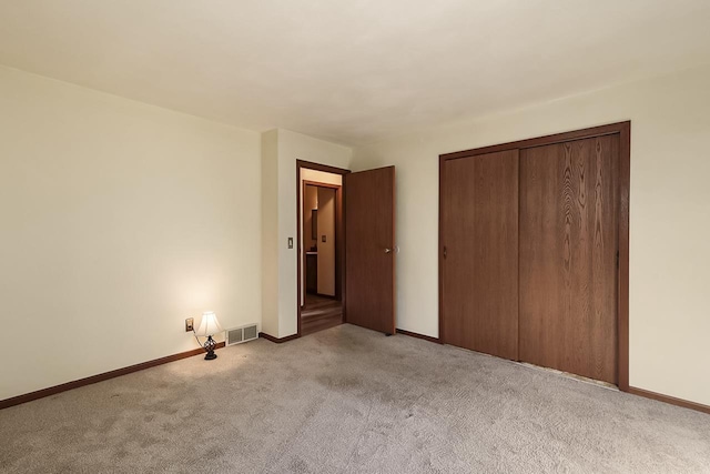 unfurnished bedroom with a closet and light carpet