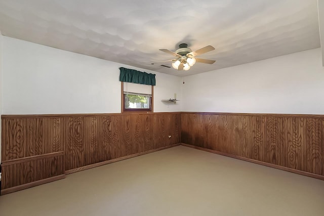 empty room featuring wooden walls and ceiling fan