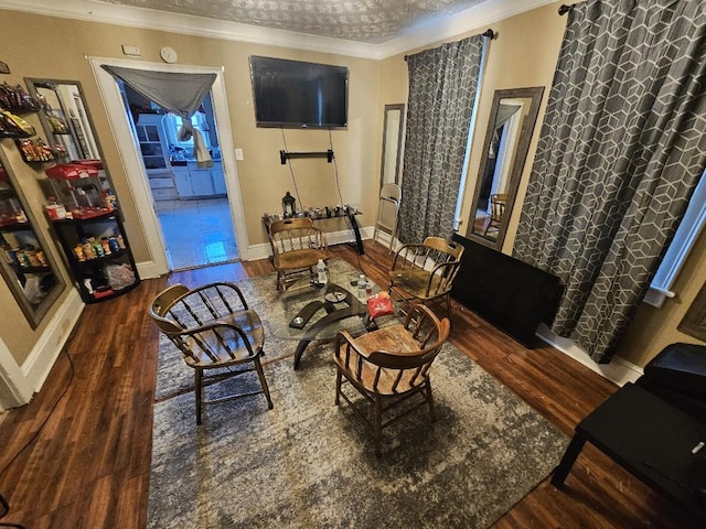 living area with crown molding and dark wood-type flooring