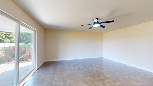 empty room with concrete flooring, baseboards, and a ceiling fan