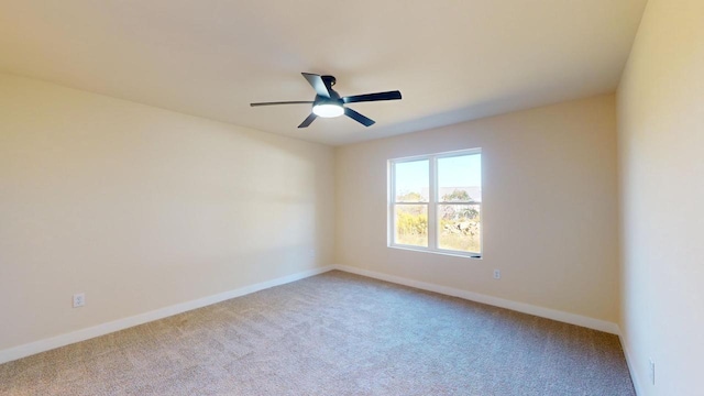 spare room featuring ceiling fan, baseboards, and light colored carpet