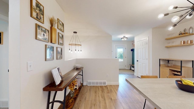 interior space featuring hanging light fixtures and light hardwood / wood-style floors