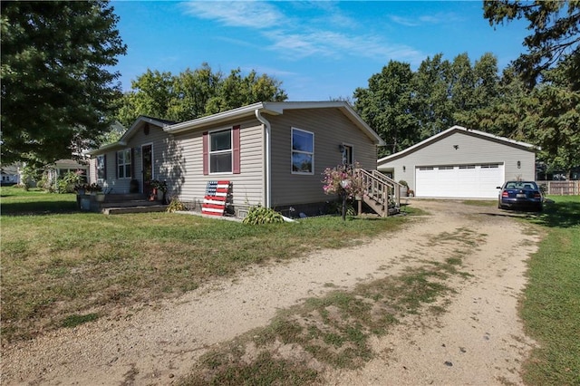 view of front of property with a front yard, a garage, and an outbuilding