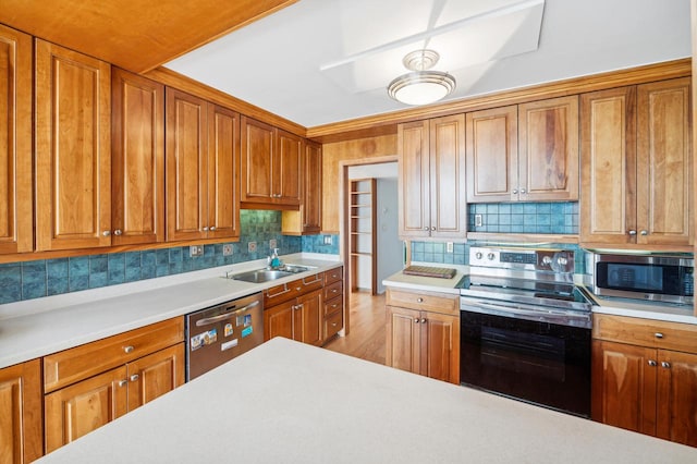 kitchen with stainless steel appliances, backsplash, light hardwood / wood-style floors, and sink