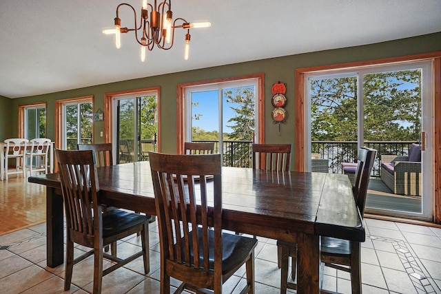 dining area featuring light tile patterned floors, a chandelier, and a wealth of natural light