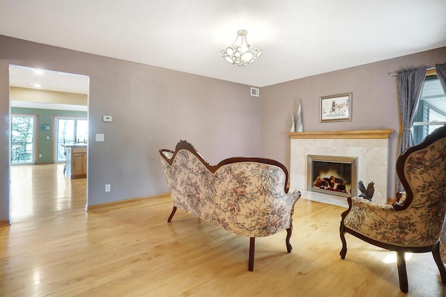 sitting room with a fireplace and light hardwood / wood-style flooring