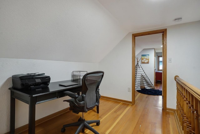 office space with lofted ceiling and light hardwood / wood-style floors