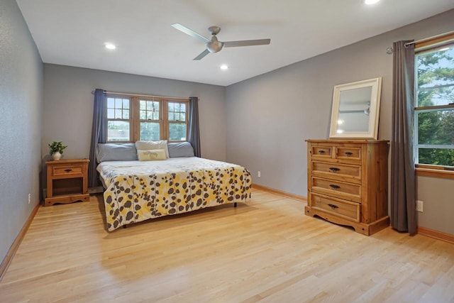 bedroom featuring light hardwood / wood-style floors, multiple windows, and ceiling fan