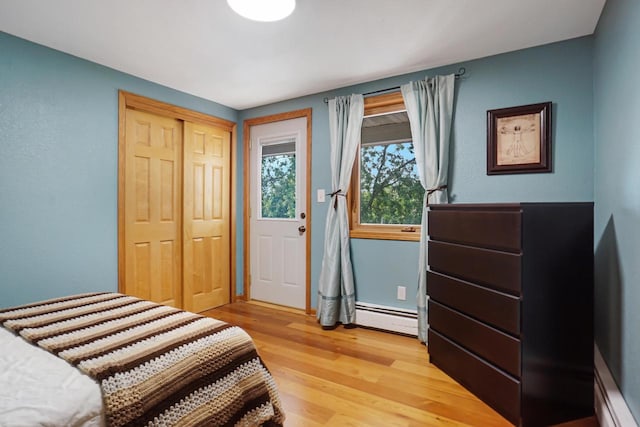 bedroom featuring light hardwood / wood-style floors, a closet, and a baseboard radiator