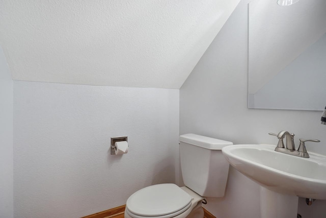 bathroom featuring sink, lofted ceiling, and toilet