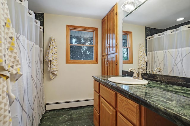 bathroom with a baseboard heating unit, vanity, and curtained shower