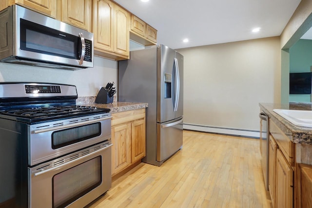 kitchen featuring light brown cabinets, stainless steel appliances, light hardwood / wood-style floors, and baseboard heating