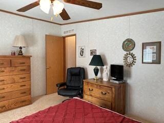 bedroom featuring carpet floors, crown molding, and ceiling fan