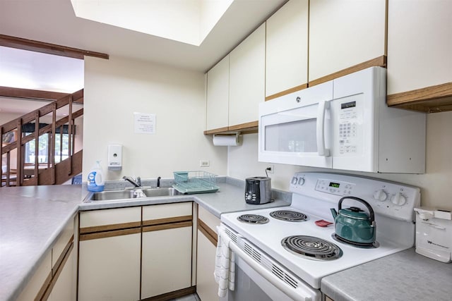 kitchen with white cabinetry, white appliances, kitchen peninsula, a skylight, and sink