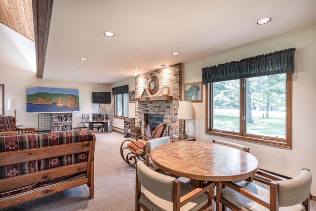 carpeted dining room with a baseboard radiator and a brick fireplace