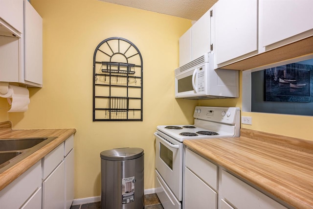 kitchen featuring tile patterned flooring, white cabinets, white appliances, and a textured ceiling