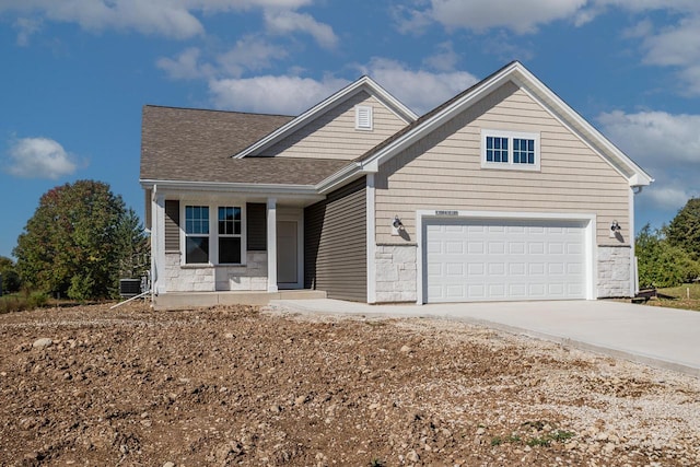 view of front of home with a garage and central air condition unit