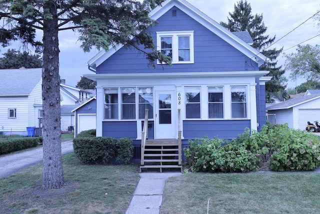 view of front of property with a garage and a front lawn