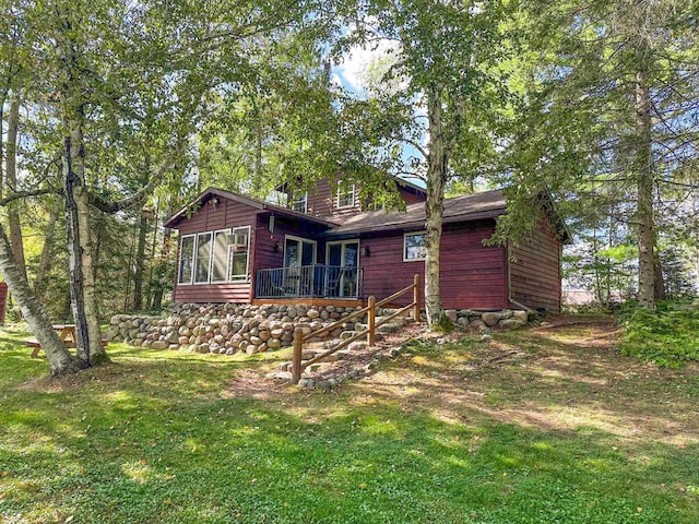 rear view of house featuring a lawn