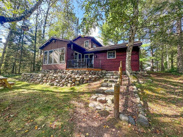 view of front of house with a sunroom and a front lawn