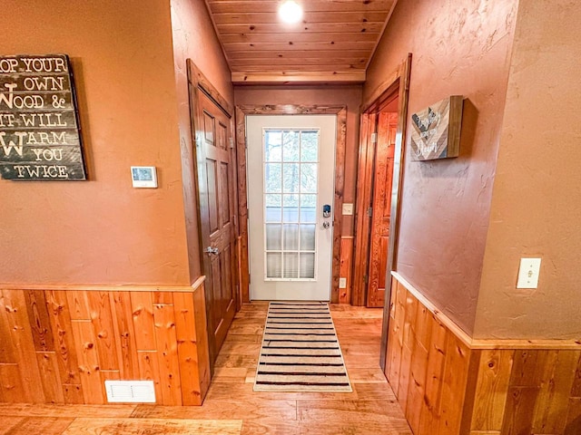 entryway featuring wooden ceiling, wood walls, and light hardwood / wood-style flooring