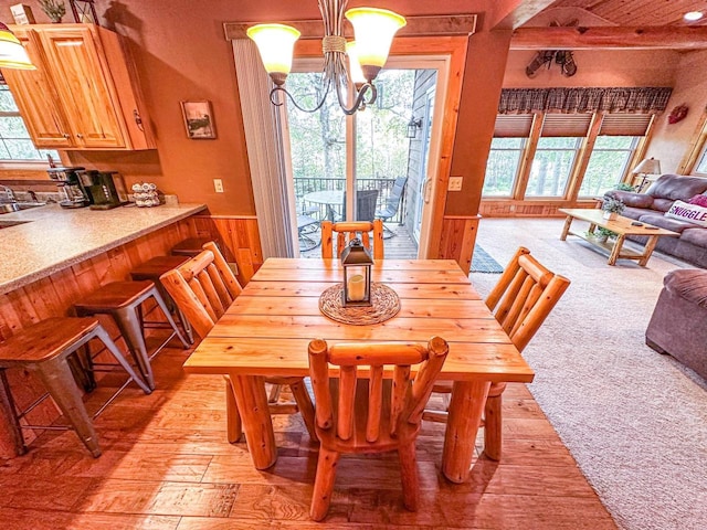 dining space with light carpet, a chandelier, and a healthy amount of sunlight