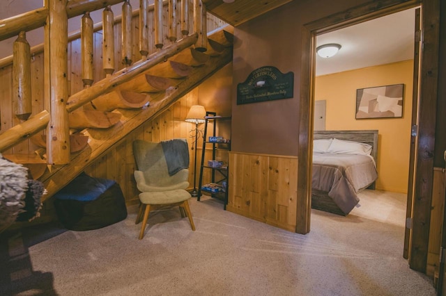 living area featuring light colored carpet and wood walls