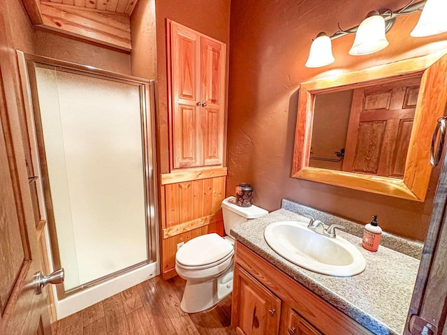 bathroom with walk in shower, hardwood / wood-style flooring, vanity, and toilet