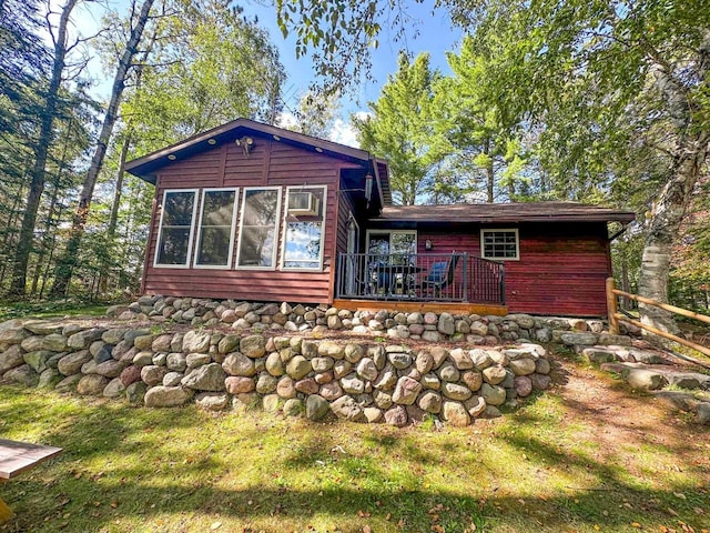 rear view of house featuring a deck and a lawn