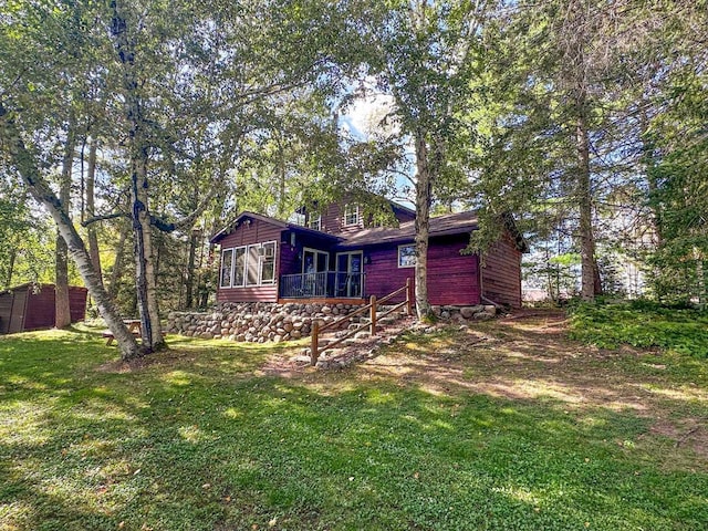 back of house featuring a lawn and a sunroom