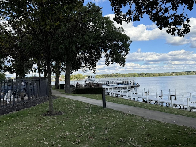 view of dock with a yard and a water view