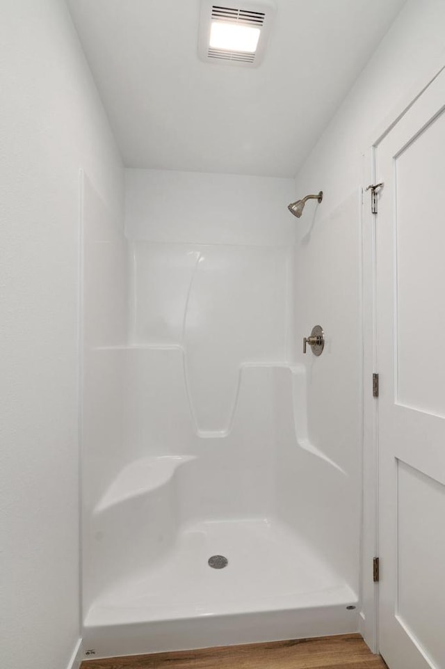 bathroom with walk in shower and wood-type flooring